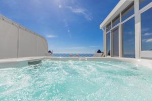 a hot tub with water in front of a house at Aurora Luxury Suites Seaview in Positano