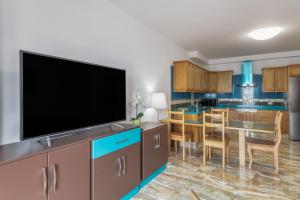 a living room with a flat screen tv and a kitchen at Luján 1a Entre Hogueras Y Luces in Puntallana