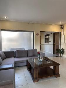 a living room with a couch and a coffee table at SBS Hotel & Spa in Asunción