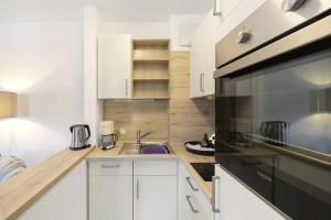 a kitchen with a sink and a microwave at Fewo Brünnstein - Nr 47 Pool, Sauna in Oberaudorf