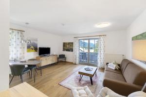 a living room with a couch and a table at Fewo Brünnstein - Nr 47 Pool, Sauna in Oberaudorf