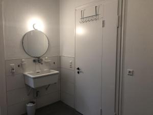 a white bathroom with a sink and a mirror at Ferienzimmer Tübingen in Tübingen +27 photos