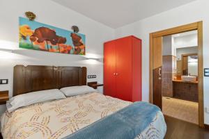 a bedroom with a bed with a red cabinet and a bathroom at L de Alborada del Eo in Villameitide