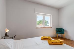 a bedroom with a bed and a chair and a window at Palmela Sunset Villa in Quinta do Anjo +25 photos