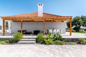 a pavilion with a table and chairs in a garden at Palmela Sunset Villa in Quinta do Anjo
