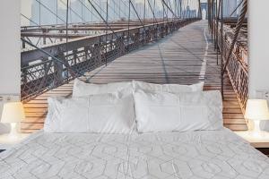 a bed with white pillows in front of a bridge at Hollywood A111 in Mijas Costa +14 photos