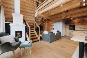 a living room with a fireplace and wooden walls at Chalet Zwoasom in Grossarl