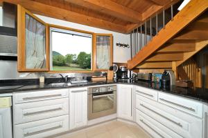 a kitchen with white cabinets and a window at Jolie Maison Vallee D'aure 4étoiles in Pailhac