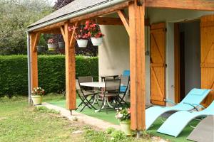a wooden pergola with a table and chairs on a patio at Jolie Maison Vallee D'aure 4étoiles in Pailhac
