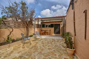 a patio with a table and chairs next to a building at Erietas House in Ágios Matthaíos