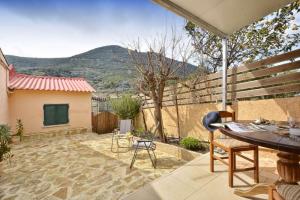 a patio with a table and chairs and a fence at Erietas House in Ágios Matthaíos +14 photos