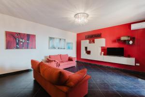 a red living room with a couch and a tv at Casa Cuore in Marsala