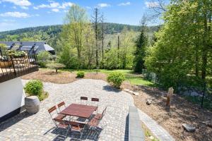 a patio with a table and chairs in a backyard at Ferienhaus Feldberg im Schwarzwald in Mittelfalkau