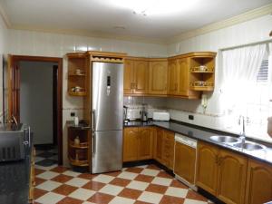 a kitchen with wooden cabinets and a stainless steel refrigerator at Casa José Romero in Arriate