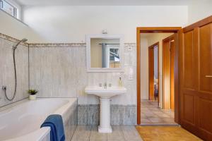 a bathroom with a bath tub and a sink at Ferienhaus Feldberg im Schwarzwald in Mittelfalkau +34 photos