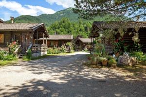 a road in front of two log homes at Orserose Chalet 1 La Bilancia in Forno di Zoldo