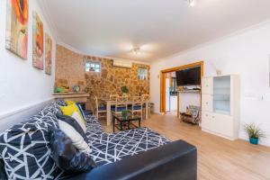 a living room with a couch and a dining room at Casa Paqui Alcudia in Port d'Alcudia