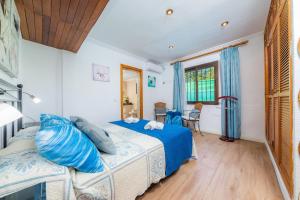 a bedroom with a bed with blue pillows at Casa Paqui Alcudia in Port d'Alcudia +17 photos