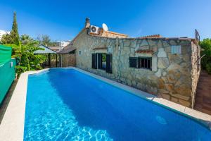 a villa with a swimming pool in front of a house at Casa Paqui Alcudia in Port d'Alcudia