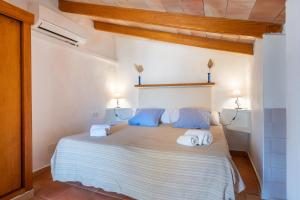 a bedroom with a large bed with blue pillows at Can Jaumins in Sóller