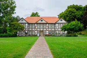 a large house with an orange roof on a green field at Harzblick am Waldesrand in Hahausen