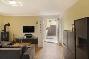 a living room with a couch and a tv at Harzblick am Waldesrand in Hahausen