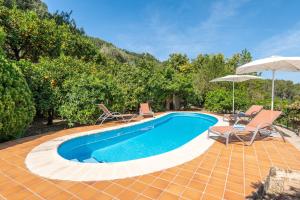 a swimming pool with two chairs and an umbrella at Can Jaumins in Sóller +17 photos
