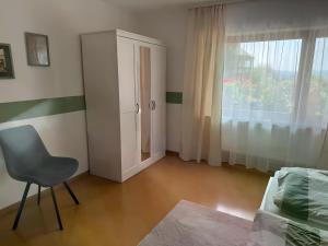 a room with a chair and a cabinet and a window at Komfort trifft Natur in Albbruck