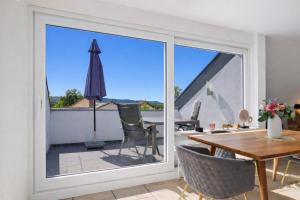 a sliding glass door leading to a patio with a table and chairs at Casa Di Napolitano 4 in Radolfzell am Bodensee