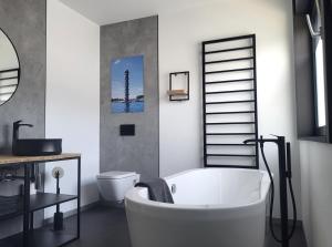 a bathroom with a white tub and a toilet at Ferienhaus Schlossterrassen 8a in Pouch +37 photos