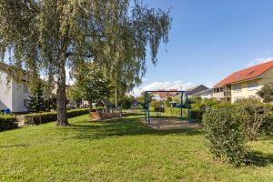 a park with a tree and a playground at Casa Di Napolitano 4 in Radolfzell am Bodensee