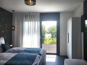 a bedroom with a bed and a sliding glass door at Ferienhaus Schlossterrassen 8a in Pouch