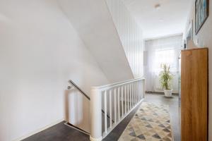 ein Flur mit einer weißen Treppe und einem Treppengeländer in der Unterkunft Lindenhardt in Creußen