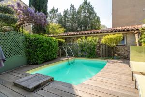 a swimming pool in a backyard with a wooden deck at Studio avec piscine à Avignon in Avignon +12 photos