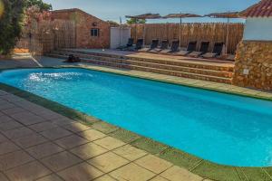 a swimming pool in a yard with chairs and a fence at Casa Rural Tesorillo Cat Superior in Cogollos de Guadix