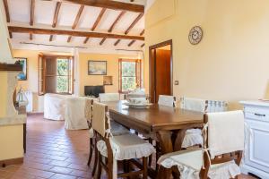 a kitchen and dining room with a wooden table and chairs at Podere Villa Rosa Torrita di Siena in Torrita di Siena