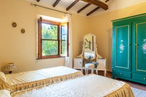 a bedroom with a bed and a window and a mirror at Podere Villa Rosa Torrita di Siena in Torrita di Siena