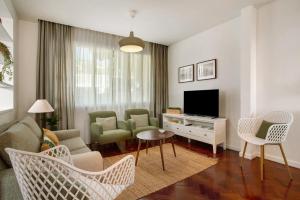 a living room with a couch and chairs and a television at Casa do Loureiro in Funchal