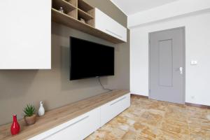 a living room with a flat screen tv on a wall at Gravedona Holiday - Lake Como in Consiglio di Rumo +9 photos
