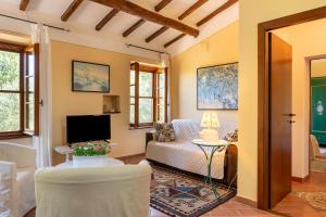 a living room with a couch and a tv at Podere Villa Rosa Torrita di Siena in Torrita di Siena