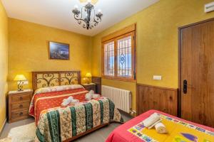 a bedroom with two beds and a chandelier at Casa Rural Tesorillo Cat Superior in Cogollos de Guadix +22 photos