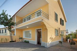 a large yellow house with a balcony at Casa do Loureiro in Funchal