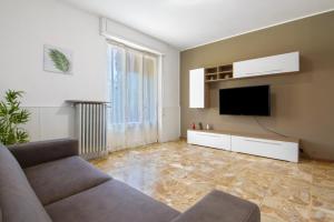 a living room with a couch and a flat screen tv at Gravedona Holiday - Lake Como in Consiglio di Rumo
