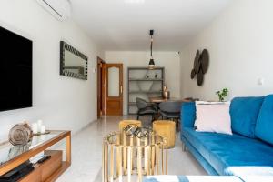 a living room with a blue couch and a table at Mirage Mijas centro in Mijas