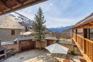 a patio with an umbrella and a fence and mountains at Cobert de Felip in Gavas