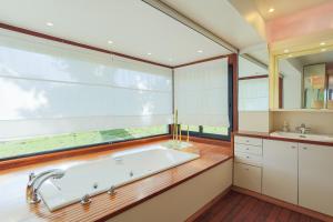 a bathroom with a tub and a large window at Maison Chevoir pieds dans l'eau in Ploubazlanec +30 photos