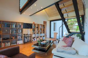 a living room with a white couch and book shelves at Maison Chevoir pieds dans l'eau in Ploubazlanec
