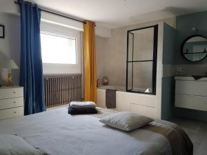 a bedroom with a bed and a window and a tub at Maison D'hôtes en Drôme Provençale in Vinsobres