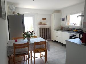 a kitchen with a table and chairs and a kitchen with a refrigerator at Maison D'hôtes en Drôme Provençale in Vinsobres