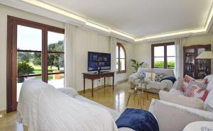 a large living room with white furniture and windows at Llum in Manacor